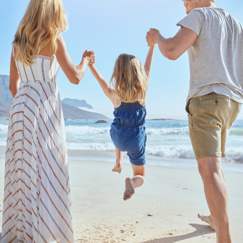 family-enjoying-fun-day-beach-playing-with-their-little-girl-rear-view-blonde-mother-father-swinging-their-cute-little-daughter-air-beach-sunny-summer-day